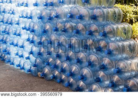 Plastic Water Bottle Background, Blue Bottle Caps, Orderly Arrangement. Empty Bottles For Drinking W