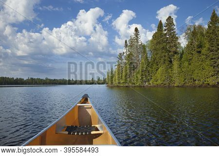 A Yellow Canoe Moving On A Northern Minnesota Lake On A Sunny Summer Morning