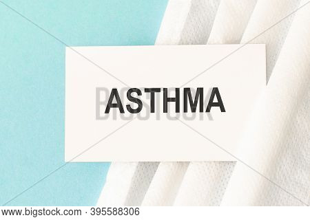 Word Asthma With Medical Mask On A Blue Background.
