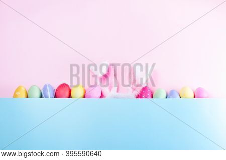Easter Rabbit Flaffy Ears And Colored Easter Colored Eggs, Top View On Pink And Blue Plain Minimal B