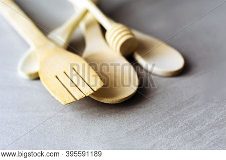 Group Of Wooden Kitchen Utensils Arranged On A Gray Marble Table. Selective Focus On The Carving For