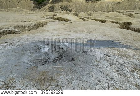 Landscape With Cracked Soil From Mud Volcanoes, At Paclele Mari, Romania. Volcanic Rocks And Lava Of