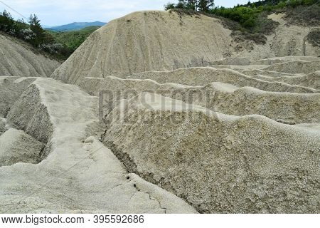 Landscape With Cracked Soil From Mud Volcanoes, At Paclele Mari, Romania. Volcanic Rocks And Lava Of