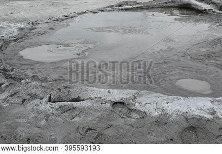 Bubbling Crater Of A Mud Volcano. Close Up View Onto Gas Bubble Exploding In Crater Of Mud Volcano. 