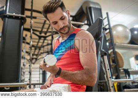 Young Dark-haired Man Working On His Arms With Dumbbells