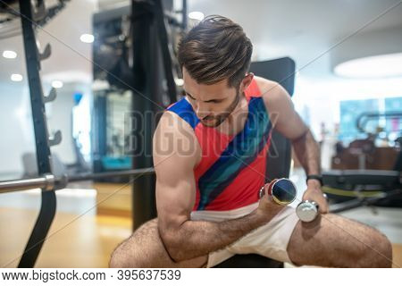 Dark-haired Man Working On His Arms With Dumbbells