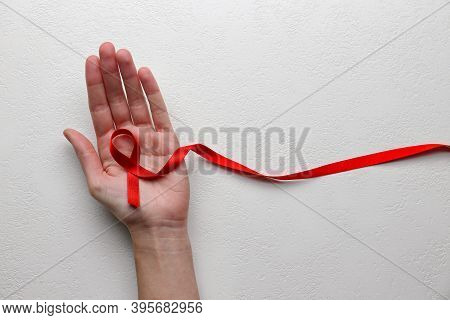Woman Holding Red Awareness Ribbon On White Background, Top View With Space For Text. World Aids Dis