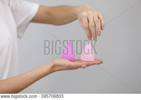Close Up Of Woman Holding In Her Hands Different Kinds Of Pink And Purple Menstrual Cups. Womans Cho