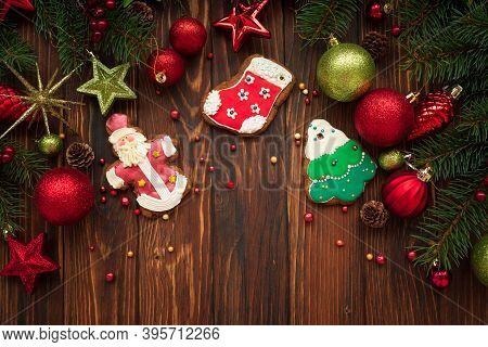 Tasty Icing Christmas Cookies On Brown Wooden Table Decorated Fir Branches And Baubbles. Traditional