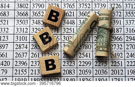 Bbb (better Business Bureau) - Acronym On Cubes On Paper Background With Numbers And Banknotes. Busi