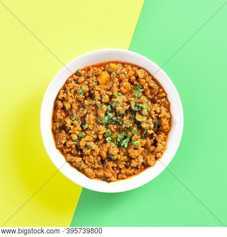 Close Up Of Keema Curry In Bowl Over Yellow Green Background With Copy Space. Indian And Pakistani S