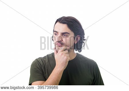 Dissatisfied Young Man Thoughtful Looking Aside, Keeps Hand Under Chin, Puzzled Negative Expression 