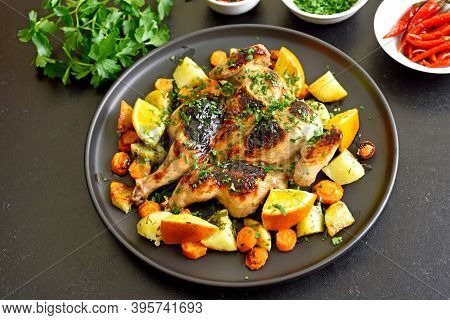 Spatchcocked Grilled Chicken With Vegetables On Plate On A Over Black Stone Background
