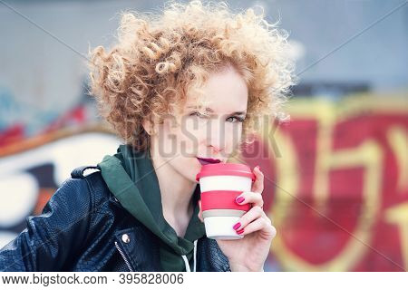 Curly Red Hair Millennial Girl Wearing In Rock Black Style Outdoors Incity Near Graffiti Wall. Hipst