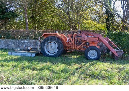 Primelin - France, October 25, 2018 : Renault Tractor With Mower Parked In The Backyard Of A Farm