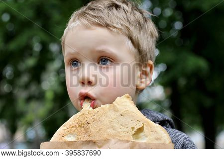 Funny Blondheared Toddler Eating Georgian Bread With Appetite On The Street.loseup Photography Of Fi
