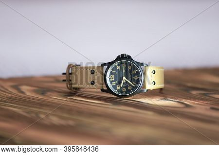 Men's Watches With A Leather Thym And A Black Dial Laid Out On A Wooden Table With A White Backgroun