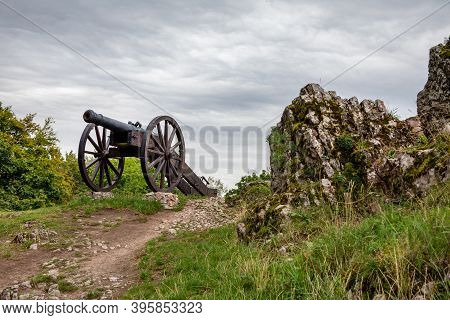 Checiny, Poland - September 06, 2020: Historic Cannon In Front Of Prison Tower And Eastern Gate Of R