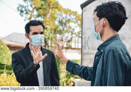 Asian Men Raised Their Hands To Greet Each Other. Avoid Spreading The Coronavirus Outside The Home T
