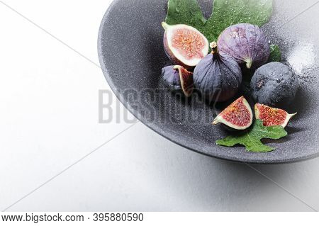Fresh Figs With Green Leafs On The Very Nice Dark Plate. White Background With Copy Space For Text.