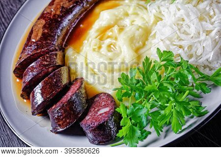 German Food: Blutwurst Or Blood Sausage Served On A Plate With Sauerkraut, Mashed Potato Parsley, Mu