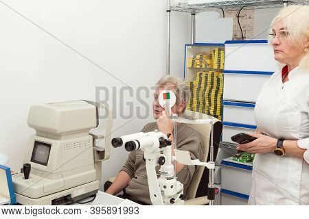 Man Checks His Eyesight At An Appointment With An Ophthalmologist In A Medical Office. Doctor And Pa