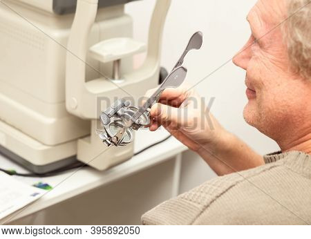 Senior Man Holding Optometric Trial Frame For The Selection Of Diopters. Ophthalmological Clinic, Vi