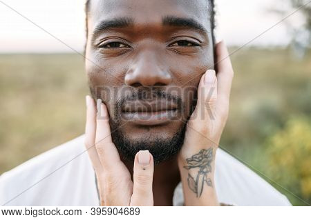 Close-up Picture Of The Face Of Handsome Black Guy, A White Female Palms Are Gently Touching His