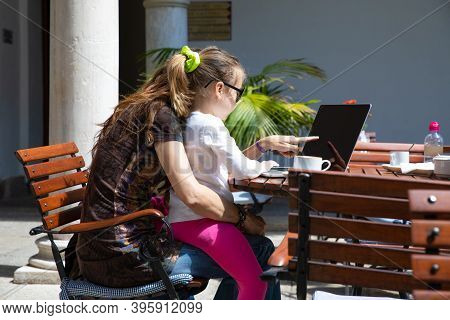 Mother Pointing Screen Laptop To Little Girl Sitting On Her Legs