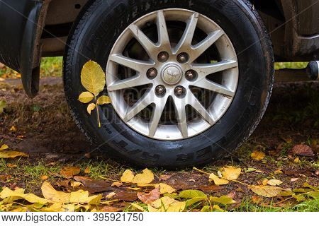 Anapa, Russia - 11.22.2020: Wet Yellow Leaves Stuck To The Tire Of A Mitsubishi Car On An Autumn Day