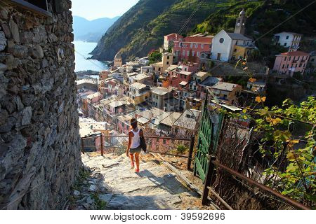 Genç waman Vernazza kasabasında küçük sokak merdivenlerde yürürken. İtalya