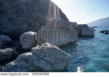 View Of Coastline Rocks With Clear Turquoise Water. Coastal Cliffs Close Up. Scenic View Of Mountain