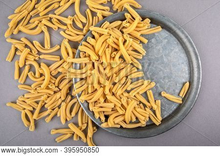 Strozzapreti, Italian Pasta In Metal Plate On A Gray Table