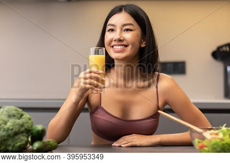 Detox Diet And Weight Loss. Slim Korean Woman Drinking Juice In Kitchen, Eating Healthy Vegetable Sa