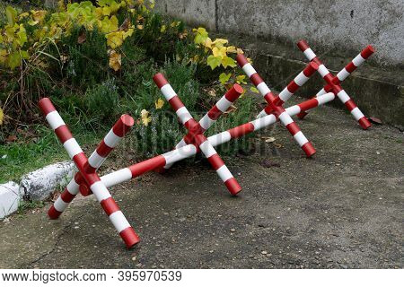 Road Barrier Hedgehog. Metal Road Barrier. Mlitary Fence With Barbed Wire Blocks The Road In The For
