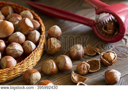 Hazelnuts With A Red Nutcracker In A Bowl On A Wooden Board, Nutshell, Dark Photo