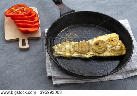 Fried Baked Mackerel Trachurus With Onions And Dried Herbs In An Old Frying Pan. Sweet Red Peppers O