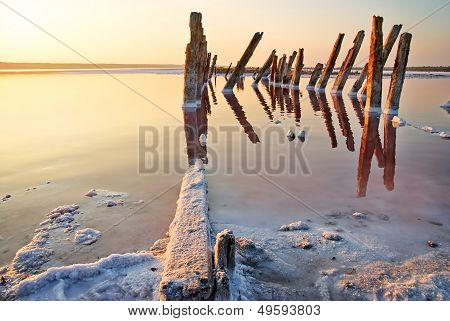 Sunset Over The Salt Lake. All Objects In This Lake Covered With Salt.