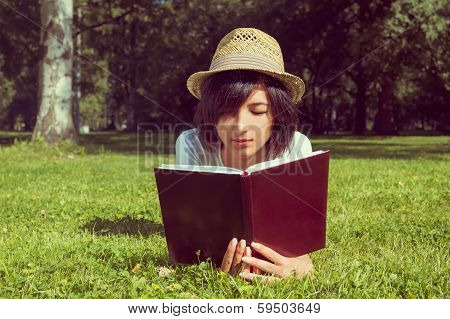 Woman Reads A Book On The Meadow