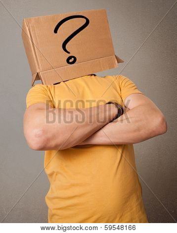 Young man standing and gesturing with a cardboard box on his head with question mark