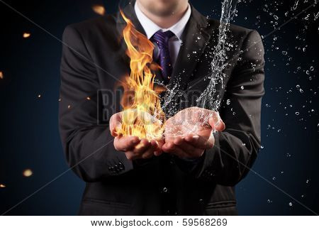 Businessman with fire and water in hands. Concept of threats and solutions as so as manager responsibility and power