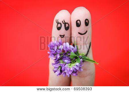Happy couple. Man is giving flowers to a woman.
