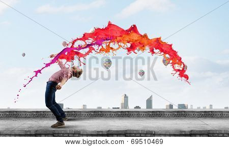 Young man in casual evading from flying icons