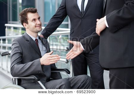 Disabled Businessman Shaking Hand With Business Partners