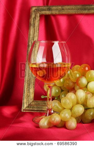 composition of frame,wine and grapes on bright background