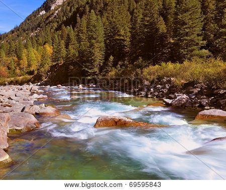 Pastoral in the Alpine mountain valley in Austria. Rapid mountain stream. Cascades of cold water at the source of the famous Krimml waterfalls.