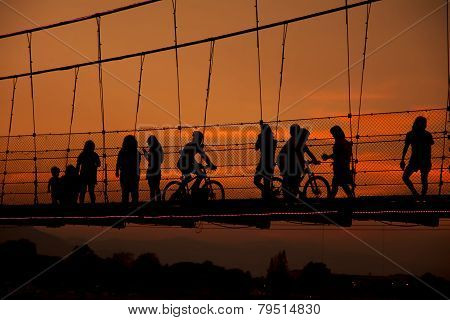 silhouette people walking on rope bridge ,Thailand