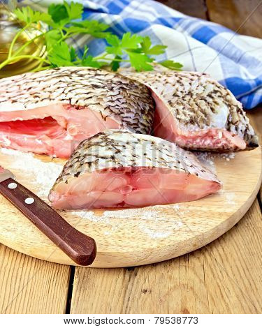 Bream crude pieces with knife on board