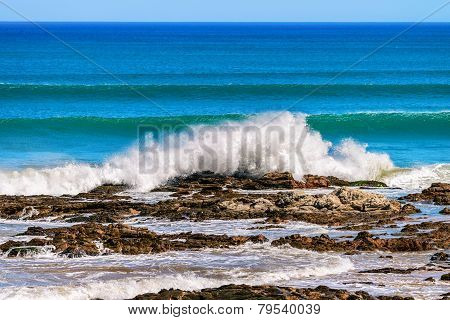 Waves crashing onto the coastal rocks