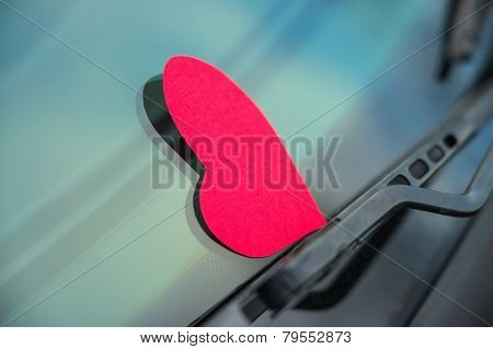 Paper shaped heart on the car window